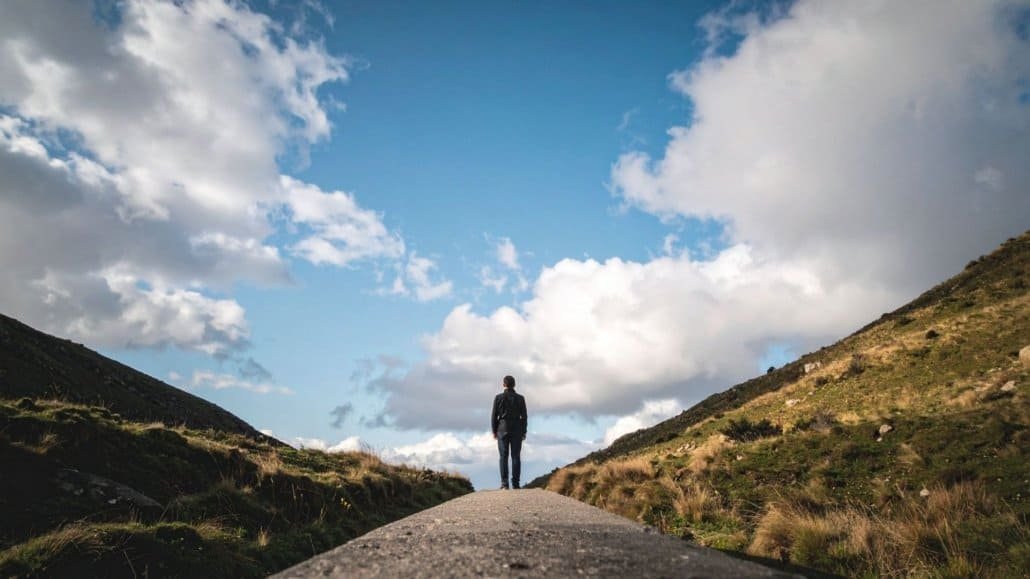 person standing between 2 landscapes representing midlife awakening