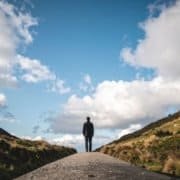 person standing between 2 landscapes representing midlife awakening