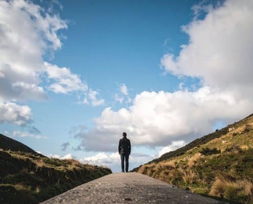 person standing between 2 landscapes representing midlife awakening