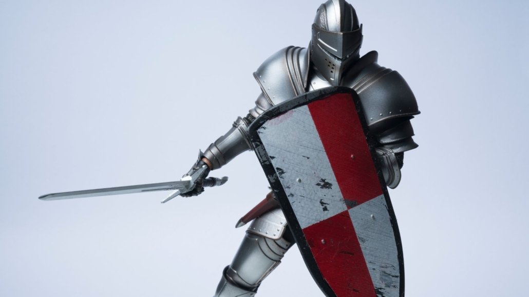 knight wearing full armor and holding a shield showing defensiveness