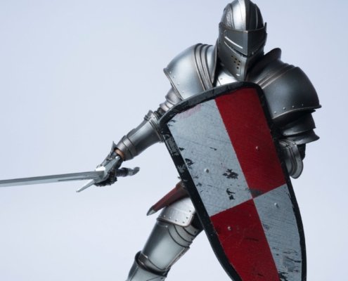 knight wearing full armor and holding a shield showing defensiveness