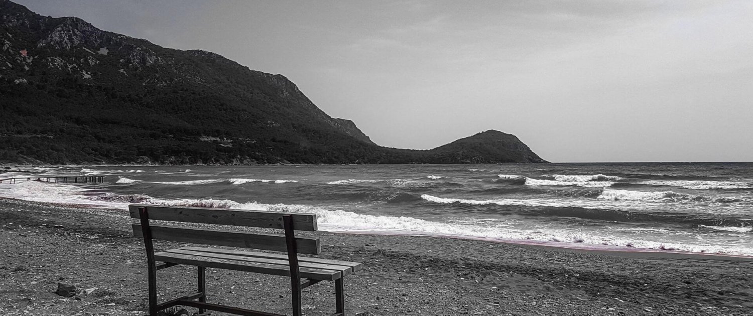 empty bench by the sea depicting loneliness