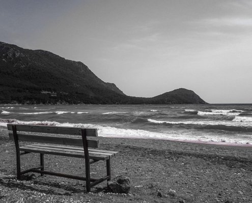 empty bench by the sea depicting loneliness