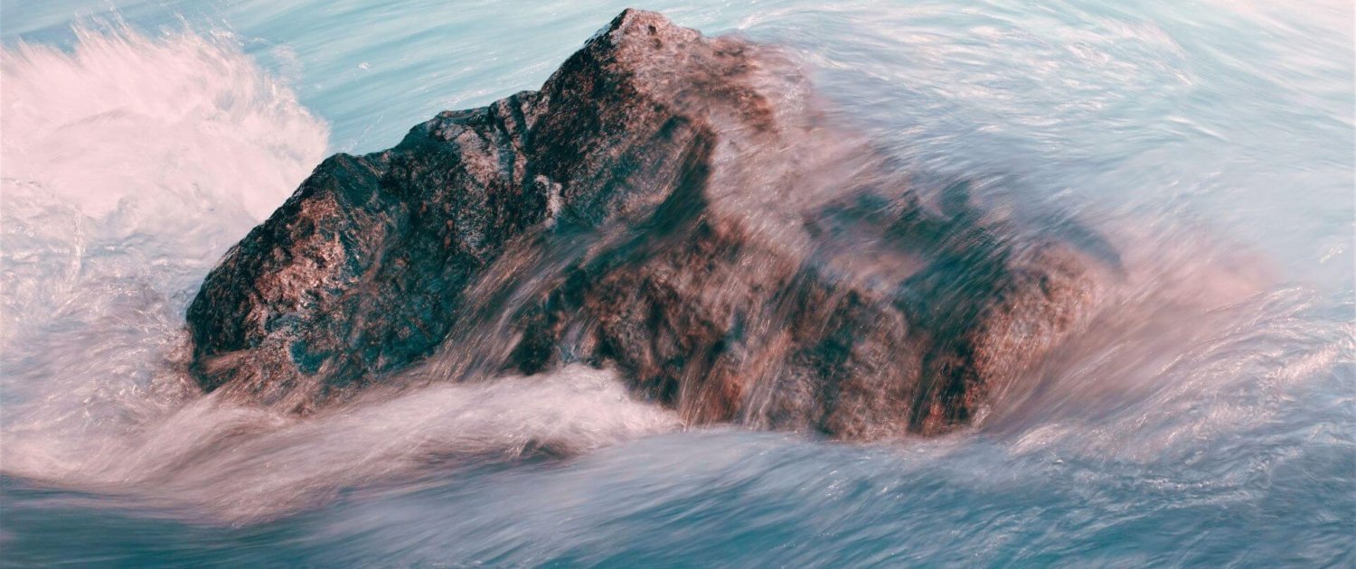 courage to belong to yourself single rock in flowing water depicting courage to belong to yourself