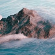 single rock in flowing water depicting courage to belong to yourself