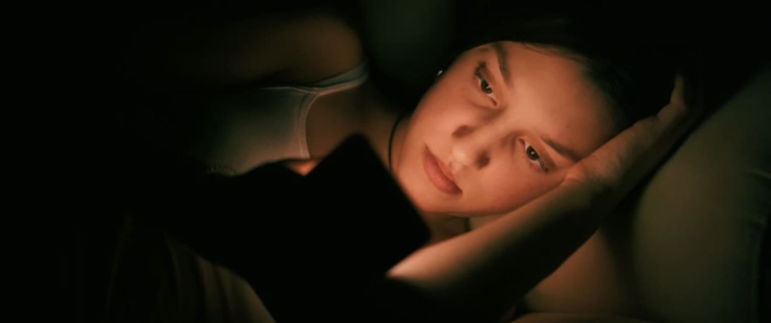 Woman alone checking dating apps on her phone