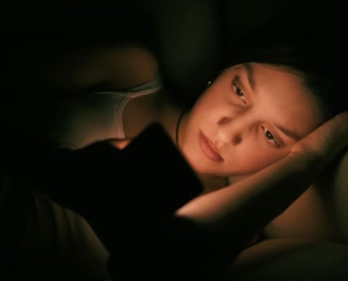 Woman alone checking dating apps on her phone